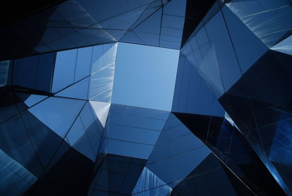 Struttura in vetro geometrica con vista verso il cielo